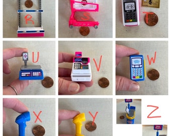 May include: A set of miniature toy grocery store items, including a pink shopping cart, a blue cash register, a blue scale, a blue credit card reader, a blue scanner, a yellow light, a blue boat, and a pink shelf. The items are arranged in a grid pattern on a white background.