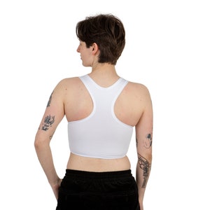 Op de afbeelding: Witte racerback crop top met een ronde hals. De top is gemaakt van een zachte, rekbare stof en heeft een strakke pasvorm.