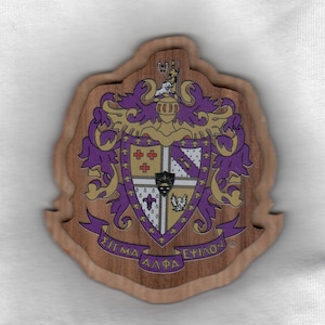 May include: A wooden emblem with a layered design. The emblem features a crest with purple and gold accents, and the Greek letters "ΣΙΓΜΑ ΑΛΦΑ ΕΨΙΛΟΝ" are displayed on a banner. The emblem has a natural wood grain finish.