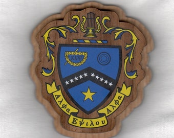 May include: A wooden plaque with a blue and gold crest featuring a lyre, a bowl, a star, and the text "Alpha Epsilon Alpha".