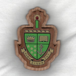 May include: A wooden shield with a green background and gold accents. The shield features a crown, a book, an anchor, and five stars. The text "Alpha Tau Sigma" is written on the shield.