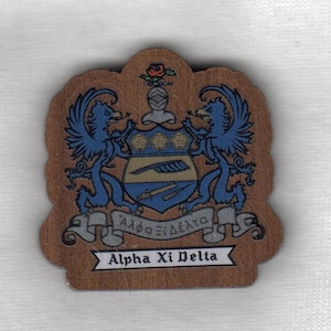 May include: A wooden crest with a blue and gold shield, two blue griffins, and a scroll with the text "Alpha Xi Delta".
