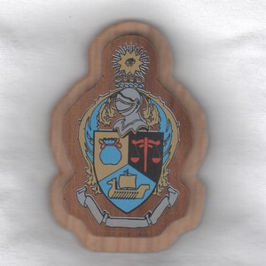 May include: A wooden plaque with a crest featuring a knight's helmet, a bag of coins, a scale, and a ship. The crest is surrounded by a wreath of leaves and scrolls. The plaque is painted in shades of brown, gold, blue, and red.