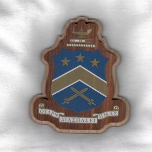 May include: A wooden plaque with a blue and gold crest featuring three stars, crossed swords, and the text "OTAEΝ ΔΙΑΣΠΑΣΕΙ ΗΜΑΣ".