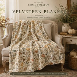May include: A velveteen blanket featuring a cream-coloured base with an intricate botanical print of orange pumpkins, brown autumn leaves, and muted green foliage. The text on the image reads Thorn & Meadow Linen Co. Velveteen Blanket.
