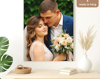 May include: A canvas print featuring a couple embracing, with the man in a blue suit and the woman in a white lace dress, holding a bouquet of flowers. The print has the text "FREE Shipping & ready to hang".