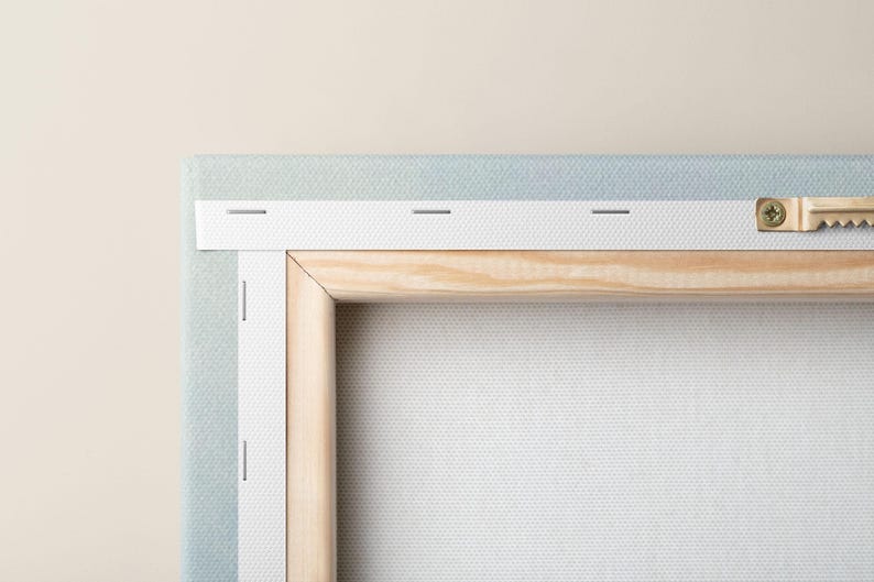 Close-up of the back of a stretched canvas showing wooden frame and hanging hardware, highlighting craftsmanship and hanging readiness.