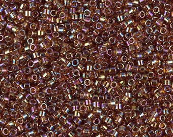 May include: A close-up image of a large quantity of small, round, iridescent glass beads. The beads are a mix of brown and gold colors with a slight purple hue.