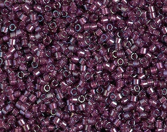 May include: A close-up view of a large quantity of small, round, purple glass beads. The beads have a slightly iridescent finish.