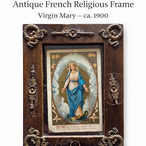 May include: Antique French religious frame featuring an image of the Virgin Mary, circa 1900. The frame is made of dark wood with ornate gold-colored accents. The image depicts Mary in a blue robe, surrounded by a golden halo. The text in the image reads "MARIE CONÇUE SANS PECHE".