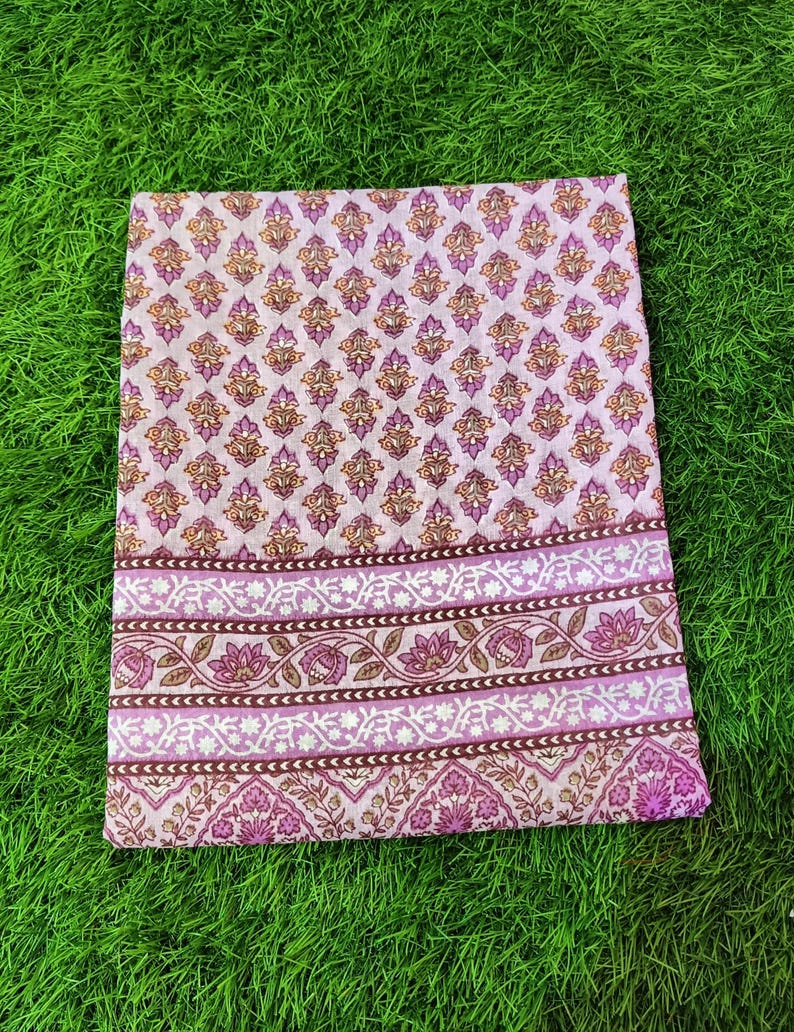 Peut inclure: Un tissu en coton rose et marron avec un motif floral. Le tissu a une bordure avec un motif r&eacute;p&eacute;titif de fleurs et de feuilles.