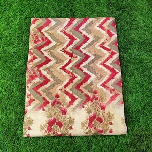 Peut inclure: Un tissu beige avec un motif chevron rouge et brun. Le tissu a &eacute;galement un imprim&eacute; floral avec des fleurs rouges.