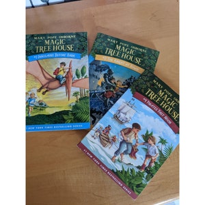 May include: Three Magic Tree House books by Mary Pope Osborne. The first book is titled "Dinosaurs Before Dark", the second is titled "The Knight at Dawn", and the third is titled "Pirates Past Noon".