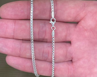May include: A silver chain necklace with a lobster clasp. The chain is a delicate, flat, and slightly textured design.