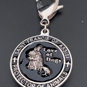 Puede incluir: Un dije plateado con un centro negro, que presenta una imagen de San Francisco de As&iacute;s con un perro. El dije dice "Saint Francis of Assisi Protector of Animals" y "Love of Dogs". Incluye un cierre plateado.