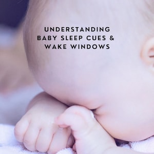 May include: A baby resting their head on their hands with the text UNDERSTANDING BABY SLEEP CUES & WAKE WINDOWS printed in black letters above the baby's head. The baby has light skin and is positioned against a soft, light-coloured fabric surface.