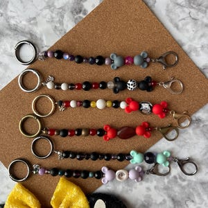Ear Holder Keychain with Carabiner (Villians). Hands-Free Travel Accessory. A Must for Days at the Parks!