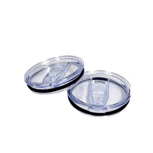 May include: Two clear plastic tumbler lids with a black rubber seal. The lids have a sliding closure mechanism. The lids are designed to fit on a tumbler or travel mug.