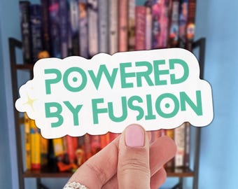 May include: A white die-cut sticker with a teal-colored sans-serif font that reads "POWERED BY FUSION" with a small four-pointed star icon on the left side. The sticker features a clean, bold design with a matte finish and a distinct white border.