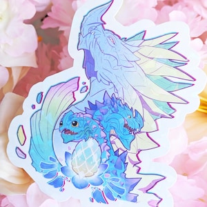 May include: A sticker featuring a fantasy illustration of a dragon family in shades of blue, purple, and yellow. The design includes a large dragon and two smaller dragons with an egg, set against a floral background.