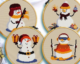 May include: Four embroidered hoop art pieces featuring different snowman designs. One snowman is holding a stick, another is holding a gift, another is holding a sparkler, and the last one is skiing.