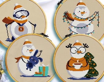 May include: Four embroidery hoops with different designs of snowmen. The first snowman is wearing ski goggles and a medal, the second is holding a string of lights, the third is holding a blue bunny, and the fourth is wearing glasses and holding a cup of coffee.