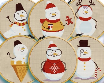 May include: Six different cross-stitch patterns featuring cute snowmen in various poses and outfits. The snowmen are wearing hats, scarves, and other winter accessories. The patterns are displayed in embroidery hoops.