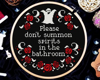 May include: Black and white embroidery hoop with a white ghost and red roses. The text reads "Please don't summon spirits in the bathroom."
