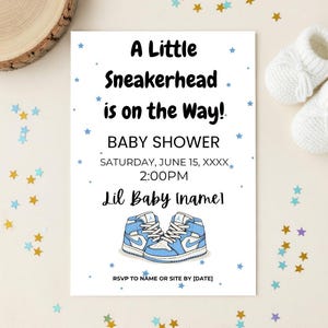 以下が含まれることがあります： 「A Little Sneakerhead is on the Way!」というテキストが黒い文字で書かれたベビーシャワーの招待状。青と白のスニーカーのペアが特徴で、青と金の星で飾られています。「Digital Download」と「Editable Template」という言葉も含まれています。