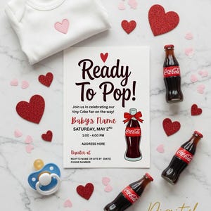 May include: A baby shower invitation with the text "Ready To Pop!" and Coca-Cola bottles. The invitation includes a white onesie with a pink heart, red glitter hearts, and a blue pacifier. Digital download.