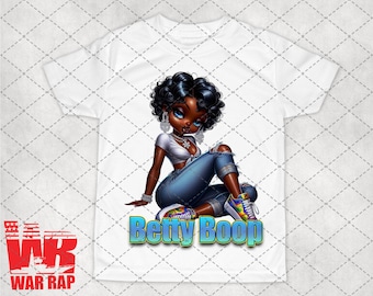 May include: White t-shirt with a cartoon image of a woman with dark skin, black hair, and blue jeans. The woman is wearing a white top and has large blue eyes. The text "Betty Boop" is printed in blue and green letters below the image.