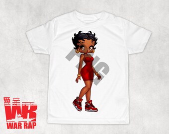 May include: White t-shirt featuring a cartoon illustration of a Black woman with red lipstick and a red dress, wearing red and white trainers. The woman is wearing gold jewellery and has a grey background behind her.