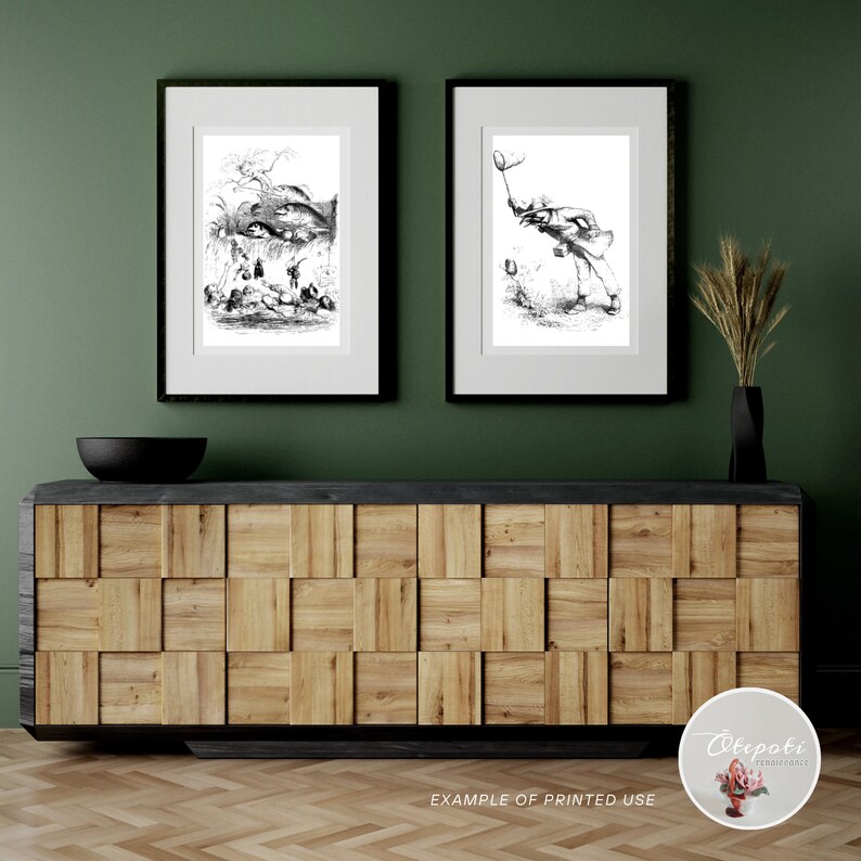 Op de afbeelding: Twee zwart-witte ingelijste illustraties van mensen in een bosrijke omgeving. De illustraties hangen aan een groene muur boven een houten kast met een zwarte bovenkant.