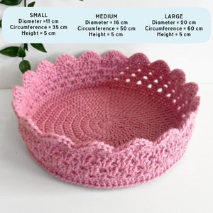 May include: A pink crocheted basket with a scalloped edge. The basket is available in three sizes: small (11 inches in diameter), medium (16 inches in diameter), and large (20 inches in diameter).