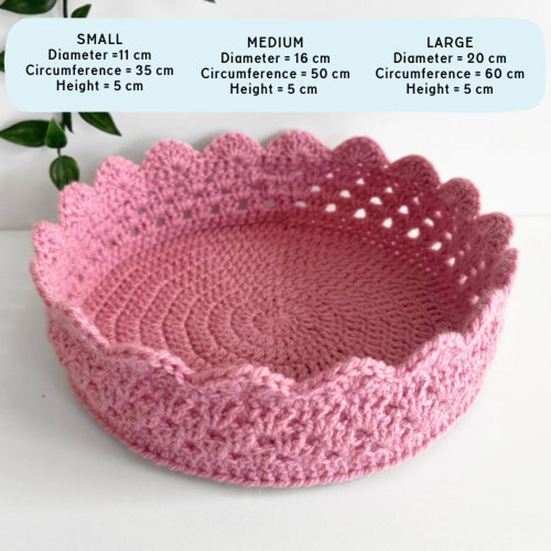 May include: A pink crocheted basket with a scalloped edge. The basket is available in three sizes: small (11 inches in diameter), medium (16 inches in diameter), and large (20 inches in diameter).