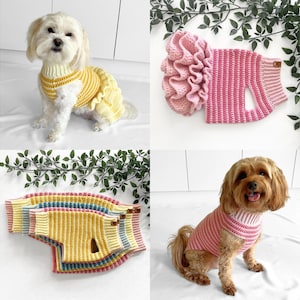 May include: Two dogs wearing crocheted dog sweaters. One dog is wearing a yellow and orange striped sweater with a ruffle. The other dog is wearing a pink and white striped sweater.