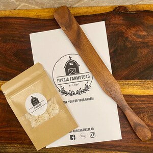 May include: A brown paper bag with a white circle sticker that says "Florence" and a white powder inside. The bag is sitting on a wooden surface next to a white sheet of paper with a black and white logo that says "Farris Farmstead Est. 2017" and "Thank you for your order!"  The paper is also next to a wooden paddle.