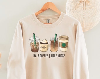 Op de afbeelding: Beige sweatshirt met een afbeelding van vier verschillende koffiedrankjes en de tekst "HALF COFFEE | HALF NURSE".