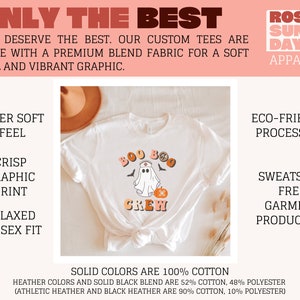 May include: White t-shirt with a graphic of a ghost wearing a nurse's hat and holding a pumpkin. The text "Boo Crew" is printed on the shirt. The shirt is laid flat on a surface with a brown hat and dried grass.