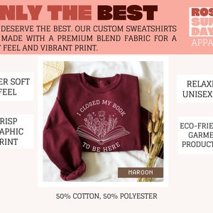 K&ouml;nnte beinhalten: Maroonfarbener Sweatshirt mit einem wei&szlig;en Grafikdruck eines geschlossenen Buches mit Blumen und dem Text "Ich habe mein Buch geschlossen, um hier zu sein". Der Sweatshirt besteht aus 50% Baumwolle und 50% Polyester.
