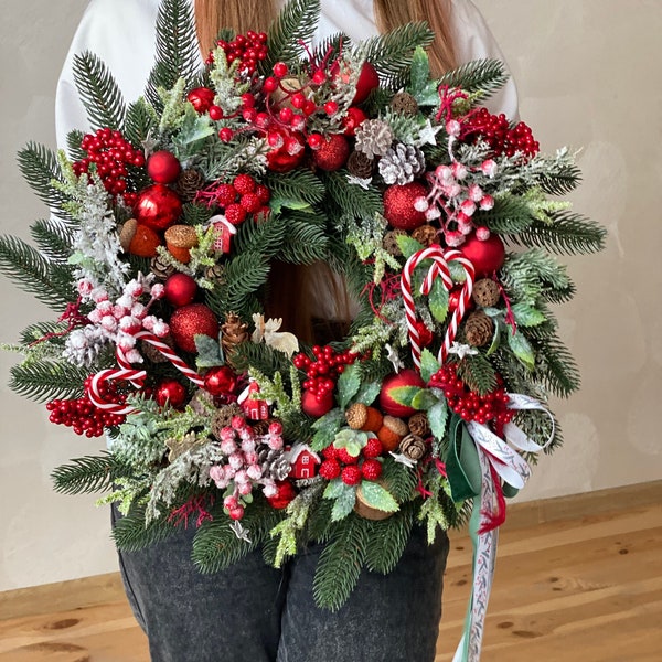 Red christmas wreath for front door with pinecones, red berries and pine.