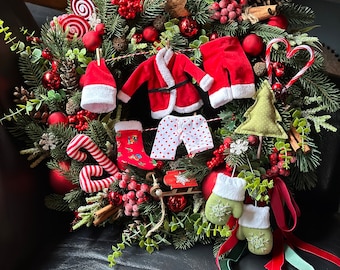 Front door mantle wreath with Santa outfit, red xmas wreath.