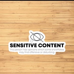 Peut inclure: Un autocollant blanc avec un œil noir barré et le texte "SENSITIVE CONTENT" avec la légende "Cette personne a des opinions que certains flocons de neige peuvent trouver offensantes ou dérangeantes."