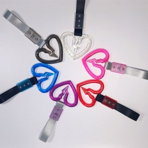 Puede incluir: Un conjunto de seis llaveros en forma de corazón con un diseño de rayo. Los llaveros están hechos de plástico transparente y vienen en una variedad de colores, incluyendo rojo, rosa, azul, morado, marrón y transparente.