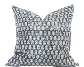 May include: A teal blue throw pillow with a white floral pattern. The pillow is made of a soft, textured fabric.