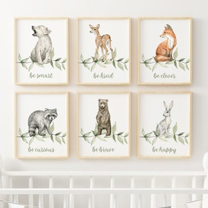 以下が含まれることがあります： 森の動物とインスピレーションを与えるメッセージが描かれた水彩画の額装が6点。それぞれの絵には、オオカミ、鹿、キツネ、アライグマ、クマ、ウサギなど、異なる動物が描かれています。絵はすべて明るい木製の額縁に収められており、背景は白です。絵に書かれたメッセージは、「賢くあれ」、「親切であれ」、「ずる賢くあれ」、「好奇心旺盛であれ」、「勇敢であれ」、「幸せであれ」です。