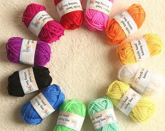 May include: A collection of colorful yarn skeins in various shades, including red, pink, purple, black, blue, green, orange, yellow, and white. Each skein has a label that reads "Acrylic hand knitting line."