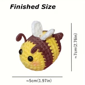 May include: A crocheted bee toy with yellow and brown stripes, white wings, and black eyes. The text Finished Size is displayed above the bee. Measurements indicate a height of approximately 2.76 inches and a width of approximately 1.97 inches.