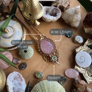 May include: A handcrafted necklace with a large rose quartz pendant, accented with gold-colored beads and brown cord. The image also features various gemstones, sea urchins, and the text "ITSORIA".