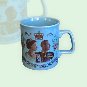 May include: A light blue ceramic mug with a picture of Queen Elizabeth II and Prince Philip. The mug commemorates the Queen's Silver Jubilee, with the years 1952 and 1977 printed on the side. The text "The Queen's Silver Jubilee" is printed on the mug.